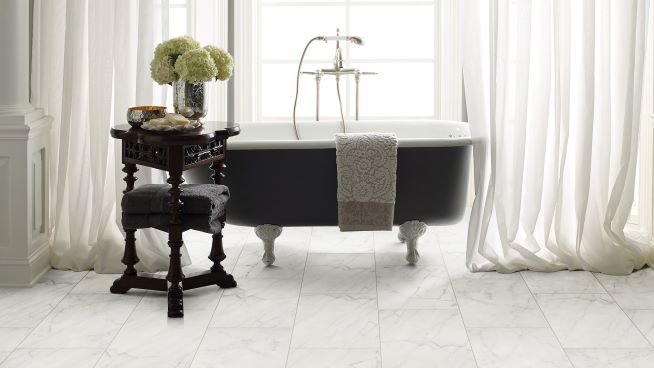 beautiful remodeled bathroom with marble tile and a standalone tub